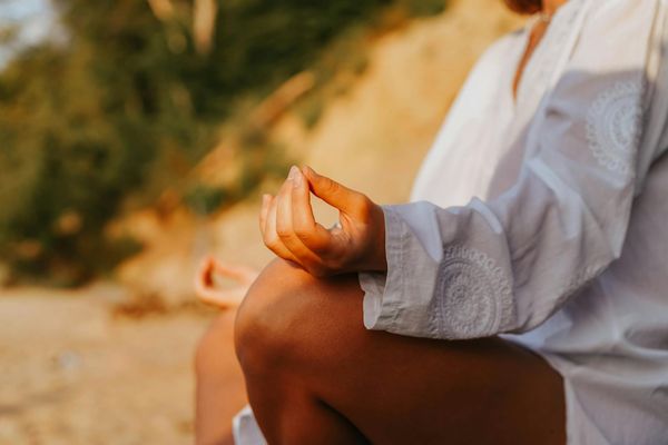 Person meditating peacefully, hands in mudra, calm expression, inner peace.